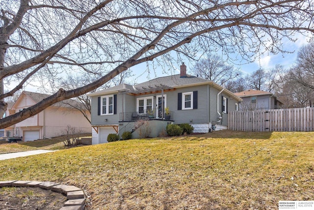 view of front of property with a front lawn, an attached garage, fence, and a chimney