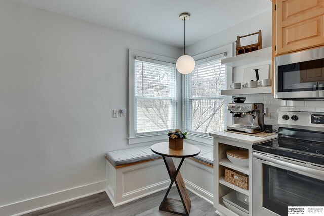 kitchen featuring wood finished floors, baseboards, open shelves, stainless steel appliances, and decorative backsplash