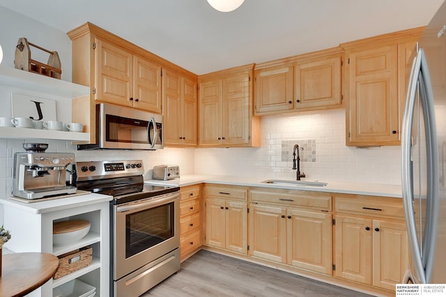 kitchen with light brown cabinets, open shelves, light countertops, appliances with stainless steel finishes, and a sink