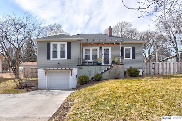 view of front of home with fence, a front yard, a chimney, driveway, and an attached garage