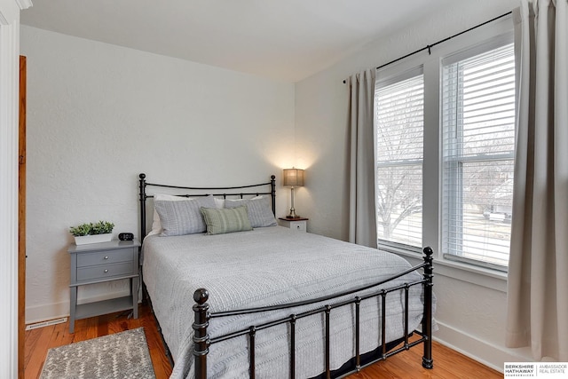 bedroom featuring visible vents, wood finished floors, and baseboards