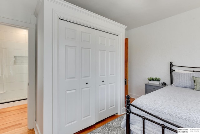 bedroom with a closet, baseboards, and wood finished floors