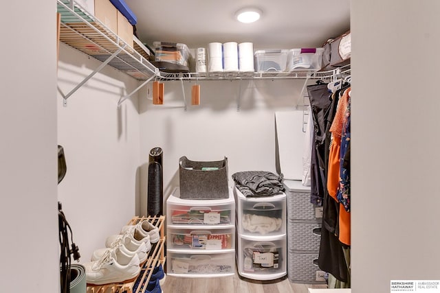 walk in closet with wood finished floors