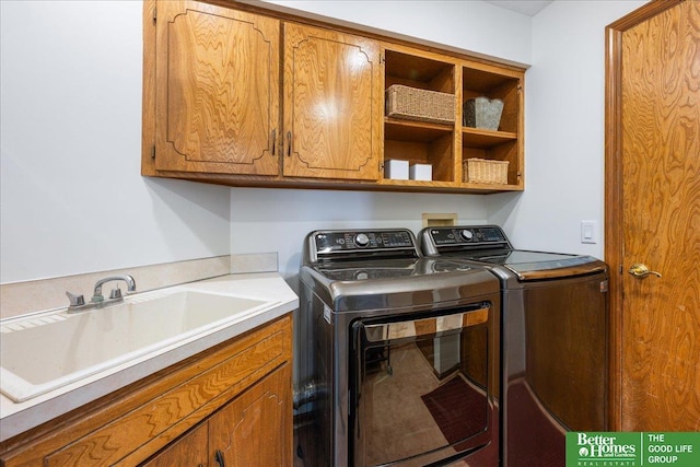 washroom with cabinet space, independent washer and dryer, and a sink