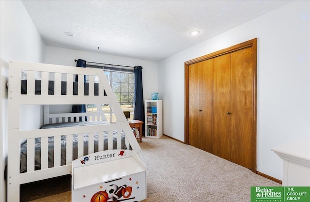 carpeted bedroom featuring a closet, a textured ceiling, and baseboards