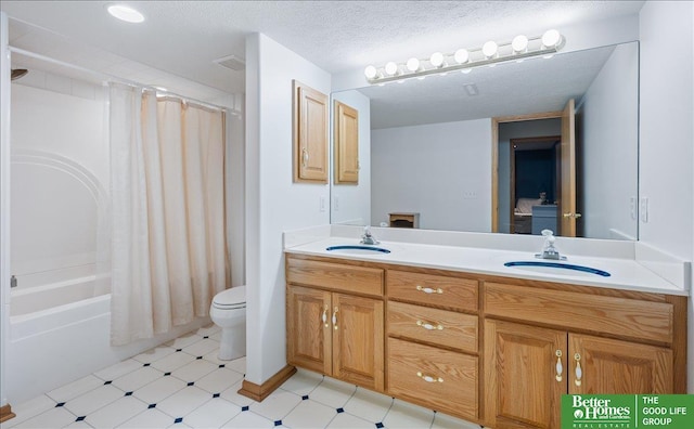 bathroom with a sink, visible vents, a textured ceiling, and double vanity