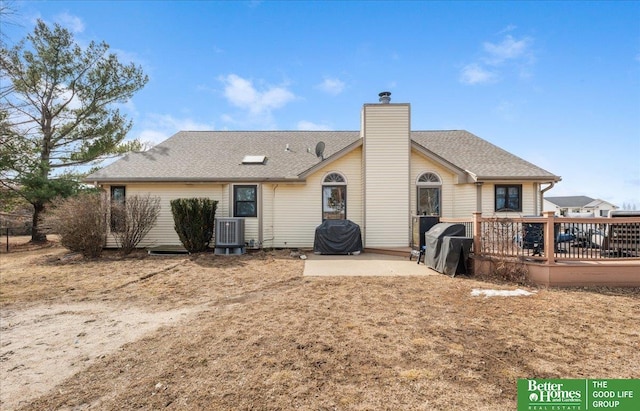 back of house with roof with shingles, central AC, a chimney, a deck, and a patio area