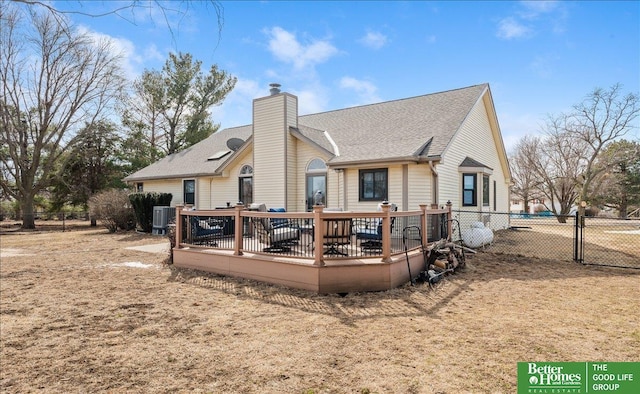 rear view of property with a wooden deck, a chimney, roof with shingles, and fence