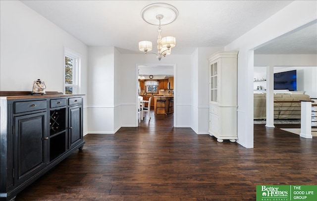 interior space featuring baseboards, wood finished floors, and a chandelier