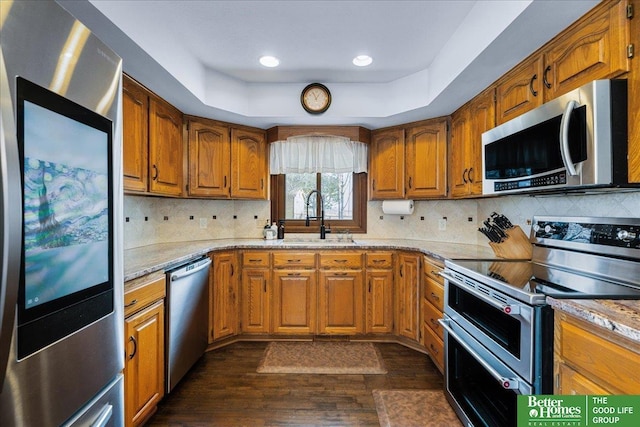 kitchen featuring brown cabinets, appliances with stainless steel finishes, and a sink