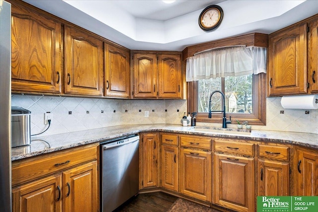 kitchen with a sink, brown cabinets, and stainless steel dishwasher