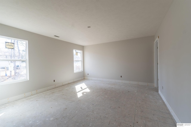 spare room featuring visible vents and baseboards