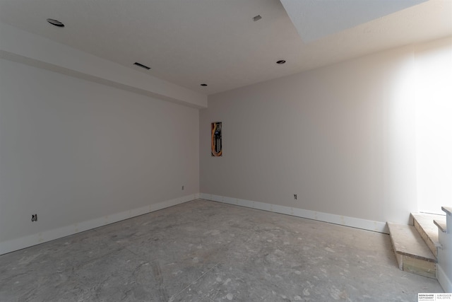 unfurnished room featuring visible vents, unfinished concrete flooring, and baseboards