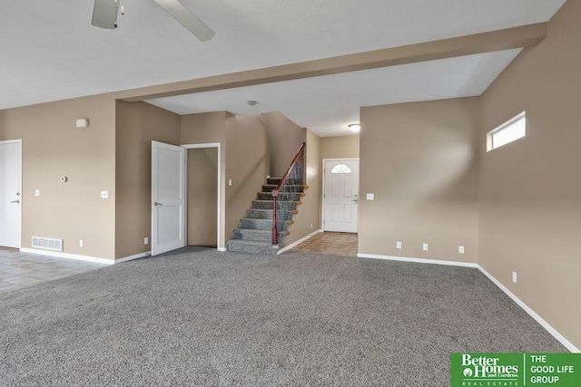 unfurnished living room with visible vents, baseboards, stairway, carpet flooring, and a ceiling fan