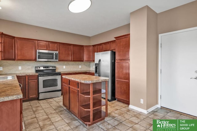 kitchen featuring backsplash, a center island, appliances with stainless steel finishes, light countertops, and baseboards