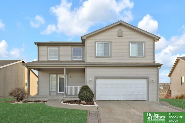 traditional home with a porch, an attached garage, driveway, and a front yard