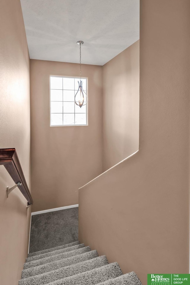 stairs featuring baseboards, carpet, and an inviting chandelier