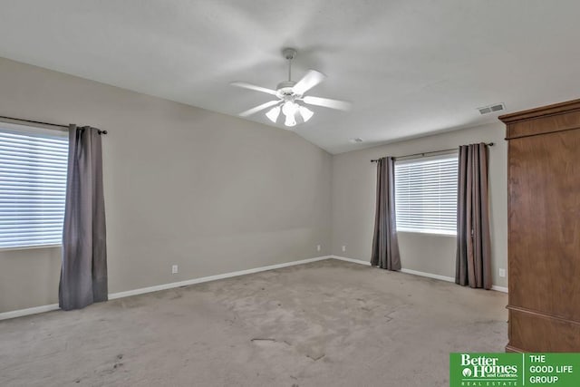 carpeted spare room with visible vents, lofted ceiling, baseboards, and ceiling fan