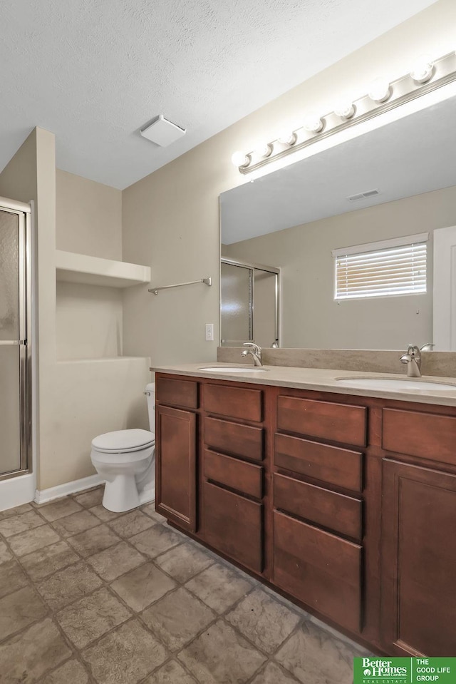 full bathroom featuring a shower stall, double vanity, and a sink