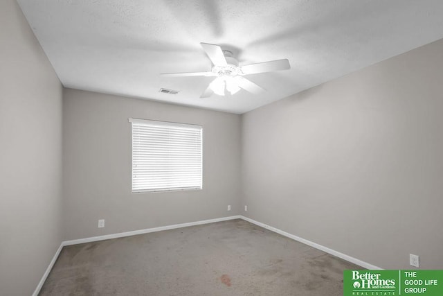 spare room featuring visible vents, a textured ceiling, baseboards, and ceiling fan