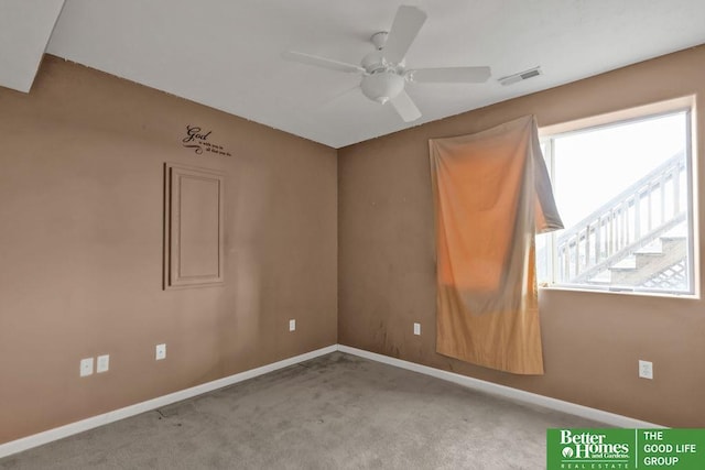 carpeted empty room with a ceiling fan, visible vents, and baseboards