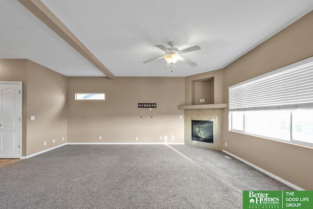 unfurnished living room with a healthy amount of sunlight, baseboards, carpet, and a ceiling fan