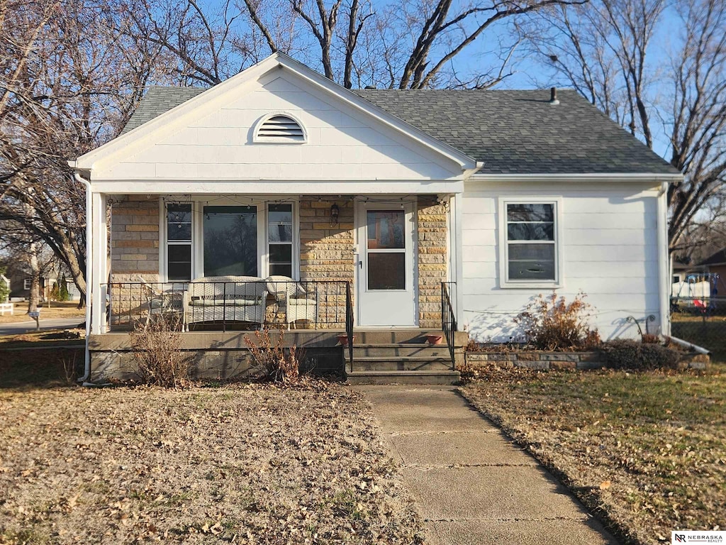 view of front of property with covered porch and roof with shingles