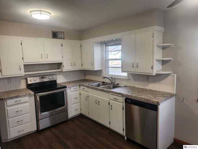 kitchen with visible vents, a sink, dark wood-type flooring, stainless steel appliances, and open shelves