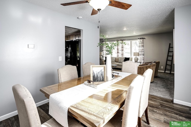 dining area featuring wood finished floors, a ceiling fan, baseboards, and a textured ceiling