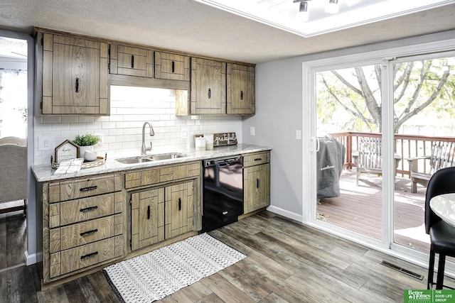 kitchen with visible vents, dark wood finished floors, a sink, decorative backsplash, and black dishwasher