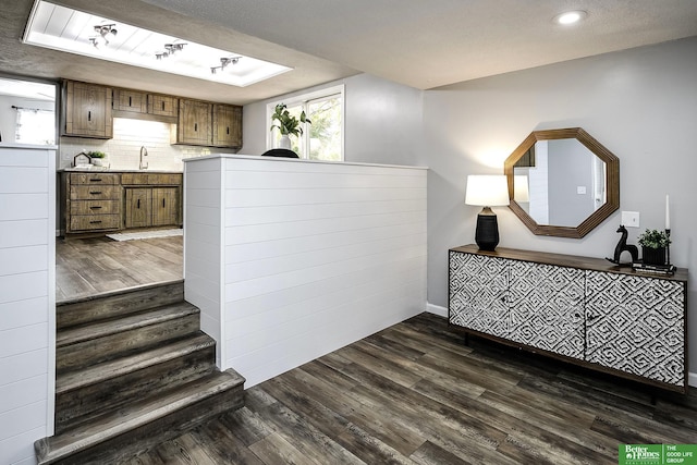 staircase with wood finished floors and a textured ceiling