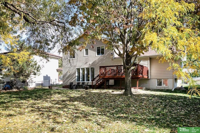 back of house with a yard, a deck, and fence