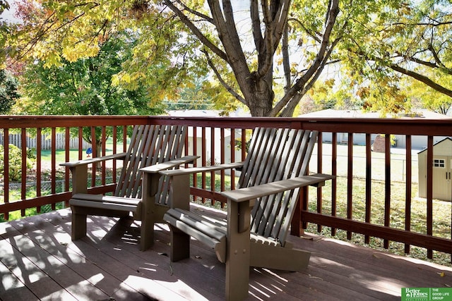 deck featuring an outdoor structure, a storage unit, and fence