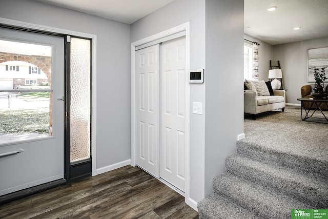 foyer entrance featuring dark wood finished floors, recessed lighting, and baseboards