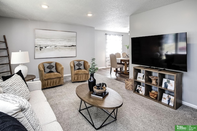 living area featuring a textured ceiling and baseboards