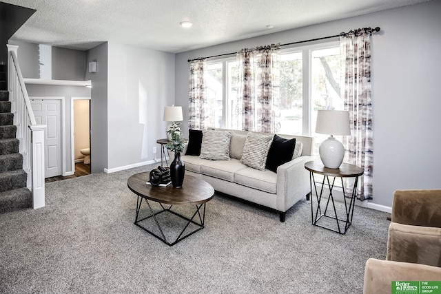 carpeted living area with stairway, baseboards, and a textured ceiling