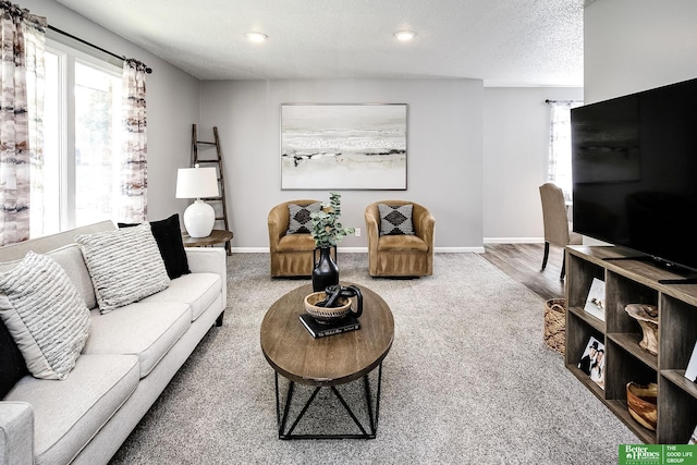 living room with recessed lighting, baseboards, and a textured ceiling