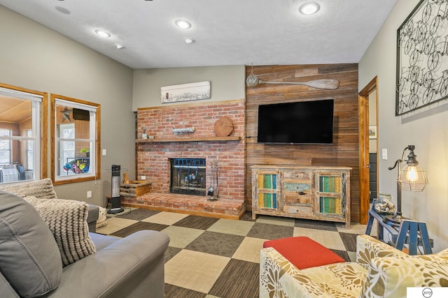 living area with recessed lighting, a fireplace, and a textured ceiling