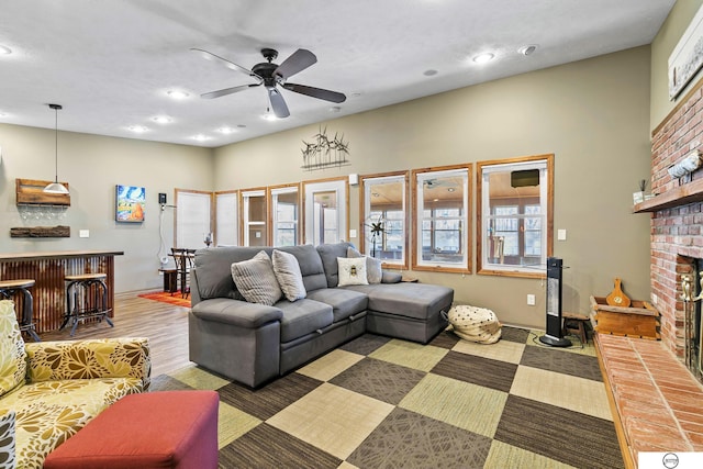 living room with wood finished floors, recessed lighting, a fireplace, a dry bar, and ceiling fan