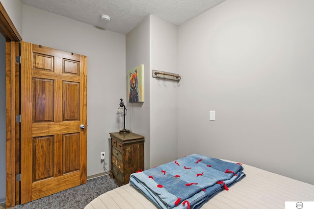 bedroom with carpet and a textured ceiling