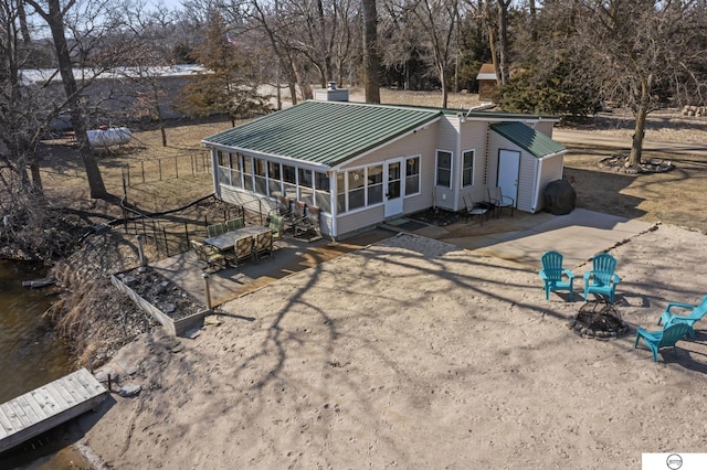 rear view of house with a patio area, metal roof, and a sunroom