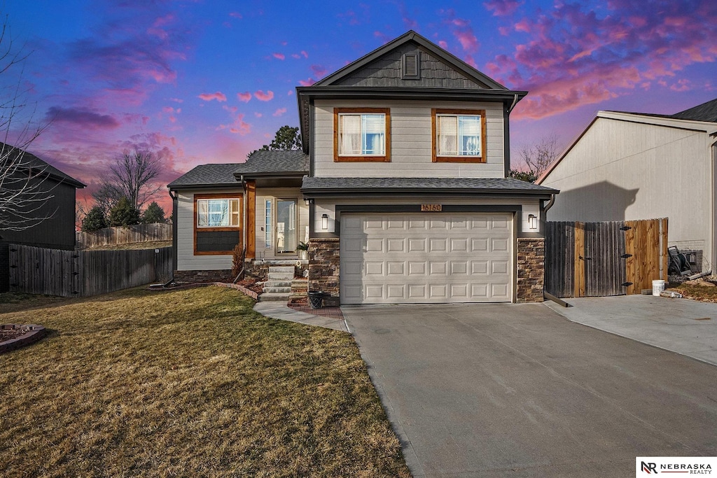 view of front of home featuring a front lawn, a gate, driveway, fence, and a garage