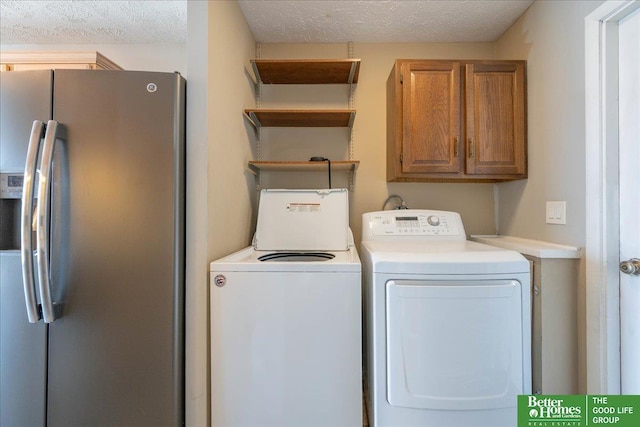 clothes washing area featuring a textured ceiling and washer and clothes dryer