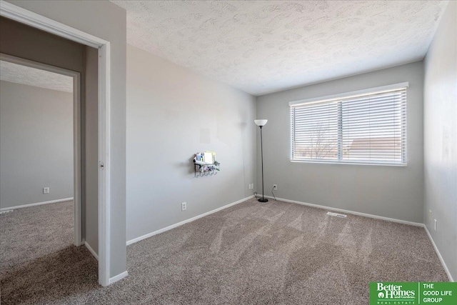 unfurnished room with a textured ceiling and carpet