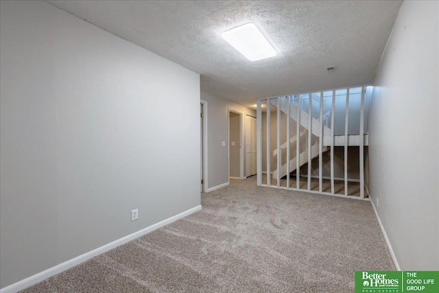 below grade area featuring baseboards, a textured ceiling, and carpet