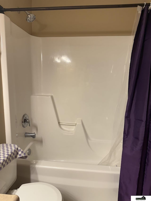 bathroom with toilet and shower / bath combo with shower curtain