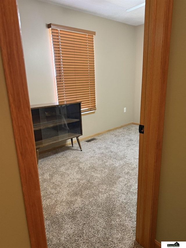 living area featuring baseboards, visible vents, and carpet floors