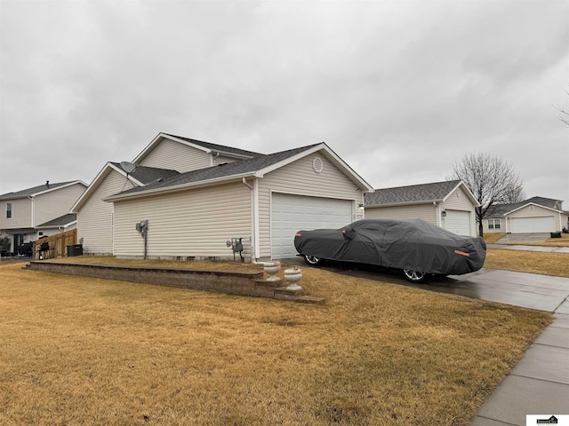 view of home's exterior featuring a yard, an attached garage, and a shingled roof