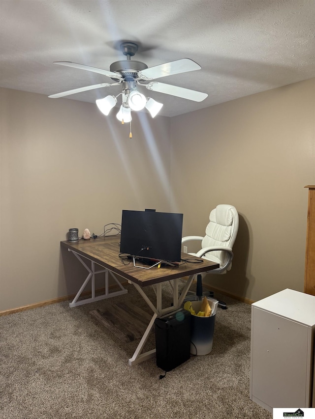 carpeted home office with a ceiling fan, baseboards, and a textured ceiling