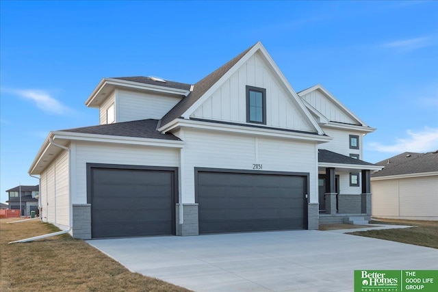 view of front of house with board and batten siding, a shingled roof, driveway, and a garage